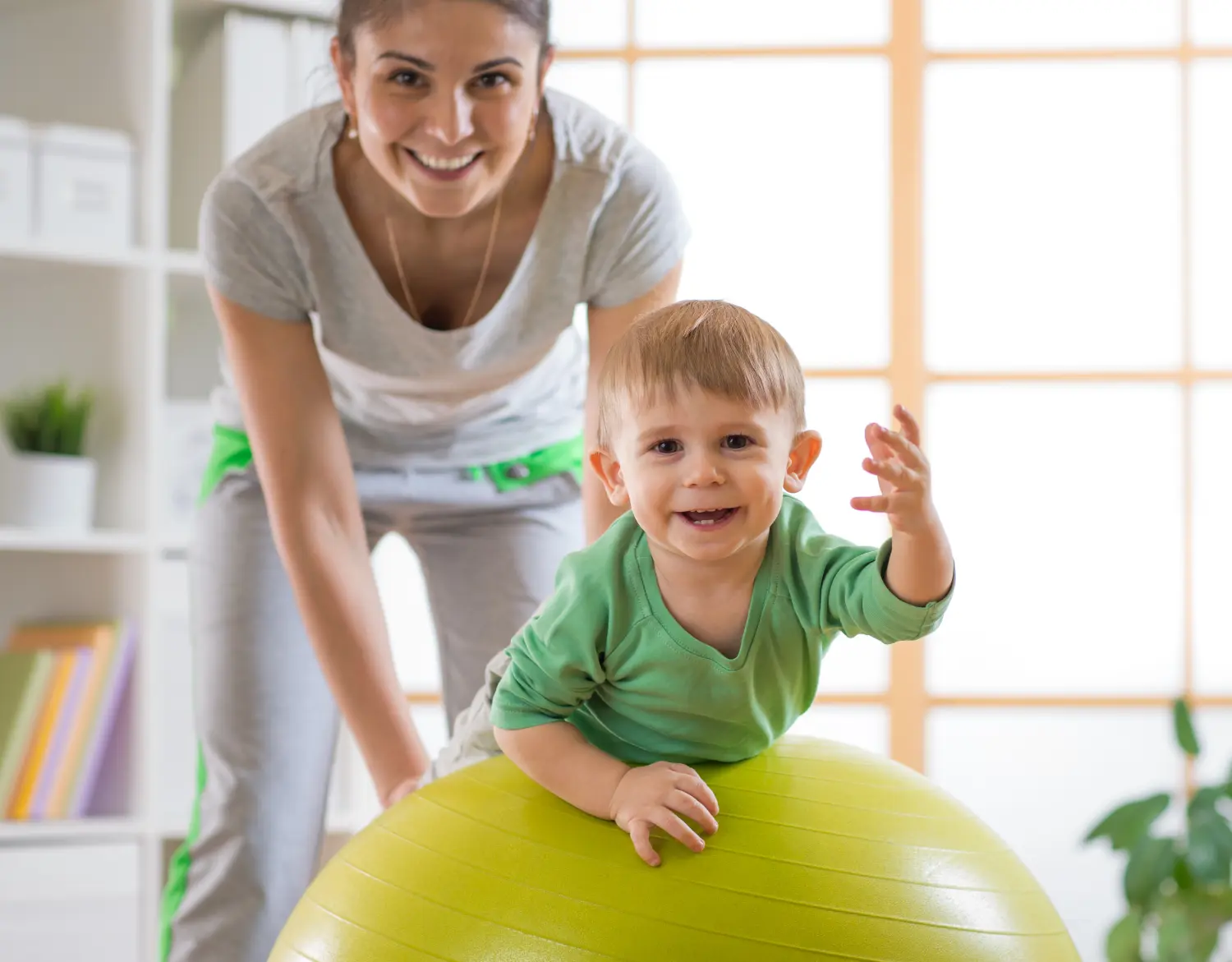 Kind spielt mit Mutter auf Gymnastikball